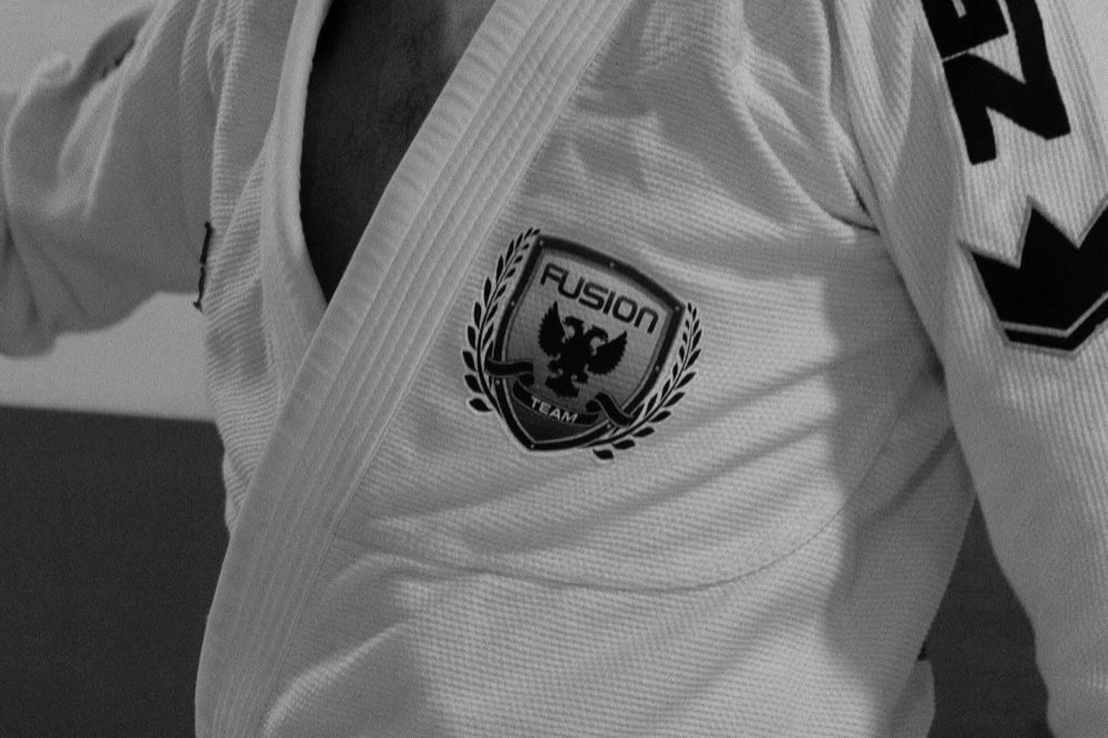 Atleta con kimono blanco y cinturón negro, con el escudo de Fusion Team